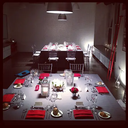 A table set with red napkins and silverware.