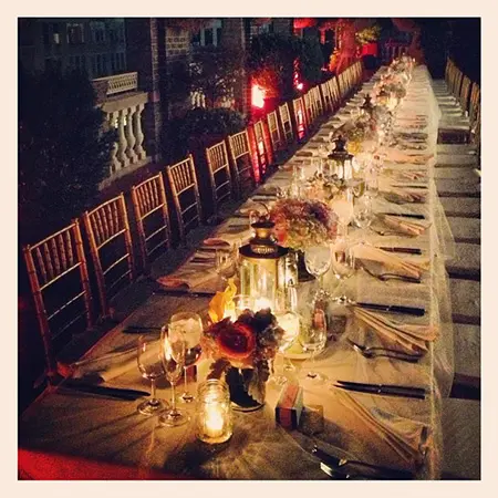 A long table with many candles and plates