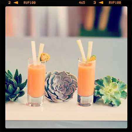 Two glasses of orange juice with a pineapple garnish.