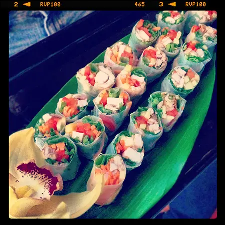 A green plate with sushi rolls on it