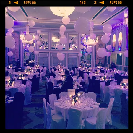 A room filled with tables and chairs, lit candles.