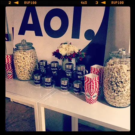 A table with popcorn and jars of nuts.