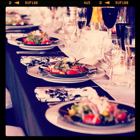 A table with plates of food and glasses on it.